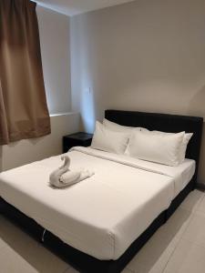a bed with two white towels on top of it at Swing & Pillows - Bukit Tinggi, Klang in Klang