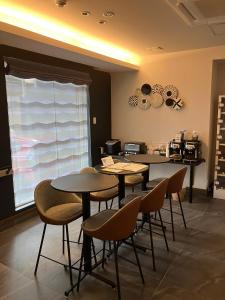a dining room with two tables and chairs and a window at HOTEL CLA-SS HIROSHIMA-TOKAICHI in Hiroshima
