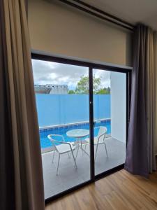 a balcony with a table and chairs and a pool at MSResort Panglao in Looc