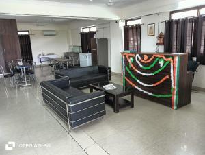 a living room with couches and a table and chairs at Hotel Mittal Tower in Jhājra