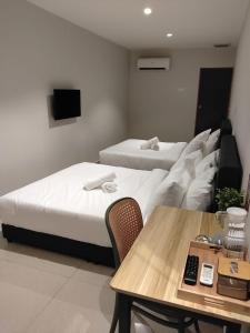 a room with two beds and a table and a couch at Swing & Pillows - Bukit Tinggi, Klang in Klang +9 photos