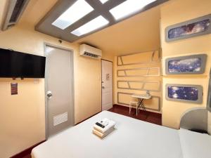 a room with a bed and a tv in a room at Astrotel Cubao in Manila