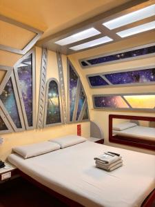 a bed in a room with a view of the universe at Astrotel Cubao in Manila