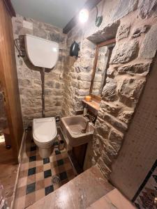 a stone bathroom with a toilet and a sink at La Torre della Bella Ragazza in Suvereto
