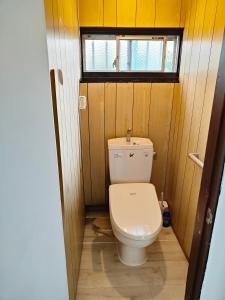 a toilet in a wooden bathroom with a window at 海っぺり宮崎 in Miyazaki +9 photos