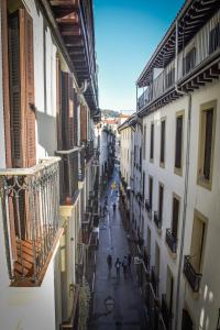 un callejón con gente caminando por una calle entre edificios en Beach Break Guesthouse, en San Sebastián