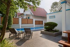 a patio with chairs and a table in front of a building at Pidoma Resort by EHM in Senmonorom