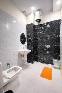 a bathroom with a sink and a toilet and a shower at The WoodLuck Zirakpur Chandigarh - Sidham Group of Hotels in Chandīgarh