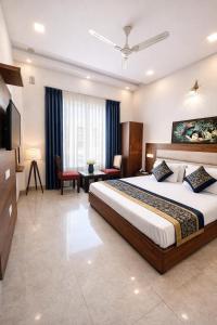 a hotel room with a large bed and a desk at The WoodLuck Zirakpur Chandigarh - Sidham Group of Hotels in Chandīgarh