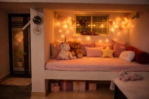 a room with a bed with teddy bears and lights at Best Homestay in Alappuzha 4 BR- LAYANILA in Alleppey