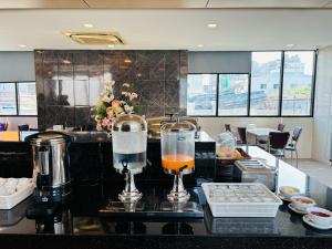 a bar with two glasses of orange juice on a counter at Pratunam Atrium Hotel in Bangkok