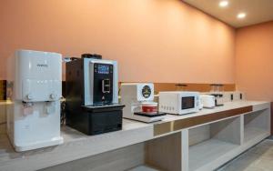 a counter with several microwaves and appliances on it at H Avenue Hotel Gyeryong Eomsa branch in Gyeryong