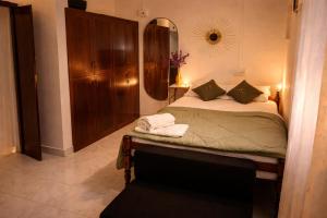a bedroom with a bed with a dresser and a mirror at Best Homestay in Alappuzha 4 BR- LAYANILA in Alleppey