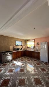 a large kitchen with a stove and a refrigerator at Hostel Acuarelas in El Chalten