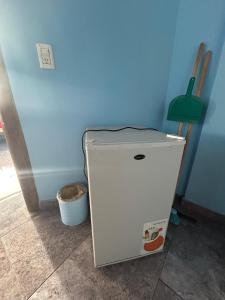 a refrigerator in a room with a blue wall at Hostel Acuarelas in El Chalten