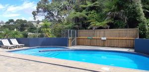 a swimming pool in a yard with a fence at Tutukaka Marina Views in Tutukaka