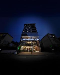 a tall building with lights on it at night at Hotel Crown Park Ltd in Sylhet
