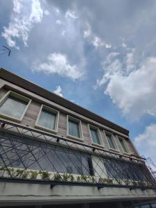 a building with windows and a sky with clouds at Horison IJ Kudus in Kudus