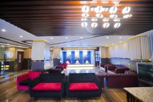 a lobby with red furniture and a chandelier at Hotel Crown Park Ltd in Sylhet
