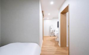 a bedroom with a white bed and a dining room at H Avenue Hotel Gyeryong Eomsa branch in Gyeryong +51 photos