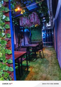 a restaurant with tables and chairs and a wall with flowers at Fairtex Luxury Hotels in Maiyegun