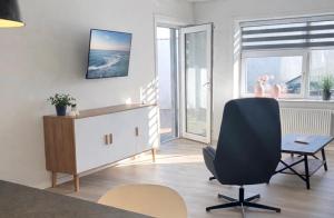 a living room with a desk and a chair at Finnsvej 12E in Frederikshavn
