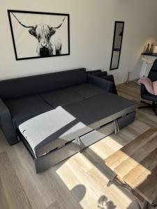 a bed in a living room with a cow on the wall at Finnsvej 12E in Frederikshavn