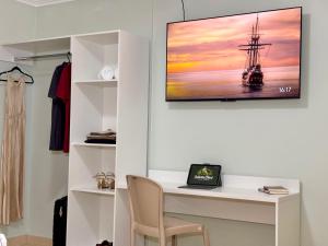 a room with a desk and a painting of a ship at Julietta House Hotel in Manaus
