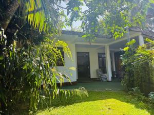 a small house with a porch and a garden at Arumathi Villa in Bentota +1 photo