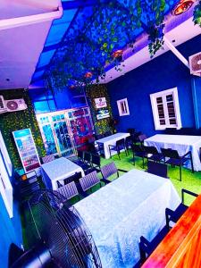 a room with tables and chairs in a room at Fairtex Luxury Hotels in Maiyegun