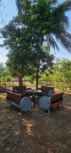 a table and chairs and a table and a tree at YR'S Nature Farmhouse in Badlapur +42 photos
