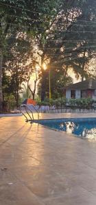 a bench in a park with the sunset in the background at YR'S Nature Farmhouse in Badlapur