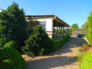 a house with a porch and some bushes at Le petit Paradis d'Hetty in Buxières-sous-Montaigut