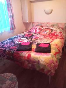 a bed in a room with a colorful bedspread at Le petit Paradis d'Hetty in Buxières-sous-Montaigut