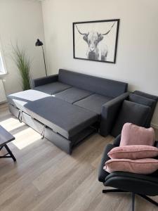 a bed in a living room with a cow on the wall at Finnsvej 12E in Frederikshavn