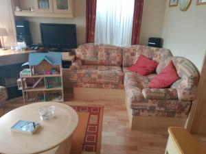 a living room with a couch and a table at Le petit Paradis d'Hetty in Buxières-sous-Montaigut