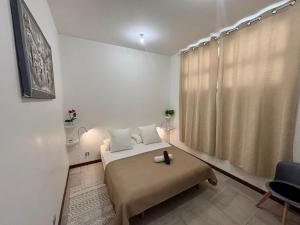 a small bedroom with a bed and a chair at Tahiti Ethnik 2 bedrooms AC Pool in Punaauia +30 photos