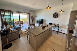 a kitchen and living room with a view of the ocean at Tahiti Ethnik 2 bedrooms AC Pool in Punaauia