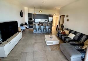 a living room with a couch and a tv at Tahiti Ethnik 2 bedrooms AC Pool in Punaauia