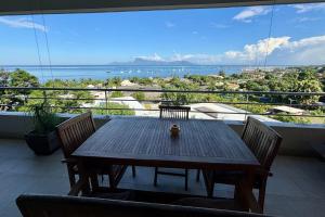 a table on a balcony with a view of the ocean at Tahiti Ethnik 2 bedrooms AC Pool in Punaauia