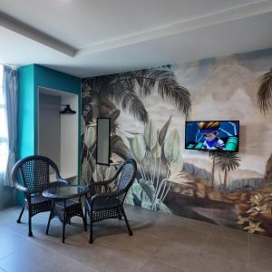 a room with two chairs and a tv on a wall at Metroinn Hotel in Arau