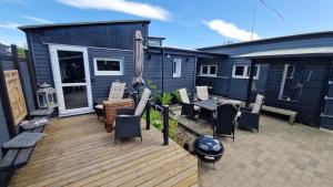 a deck with a table and chairs and a house at Nalle's in Stavtrup