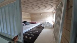 a small room with a bed in a wooden room at Nalle's in Stavtrup