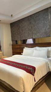 a bedroom with a large white bed with a headboard at Da Rucci Hotel syariah in Medan +7 photos