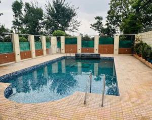 a swimming pool in a yard with a fence at Aaliya Farm House in Dhauj