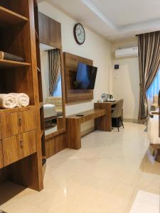 a living room with a tv and a desk at Da Rucci Hotel syariah in Medan