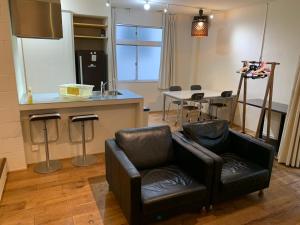 a living room with a chair and a table at ホテル スミヨシホルモン in Tokyo