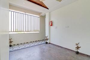 an empty room with a large window and white walls at Hotel O Dhurva Inn in Nagpur +28 photos