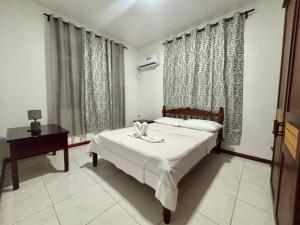 a bedroom with a bed and a table and window at Perle rare Lodge in Diamond Island +12 photos