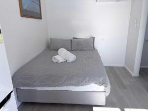 a bed with two towels on it in a room at Claremont Comfort Cottage in Claremont